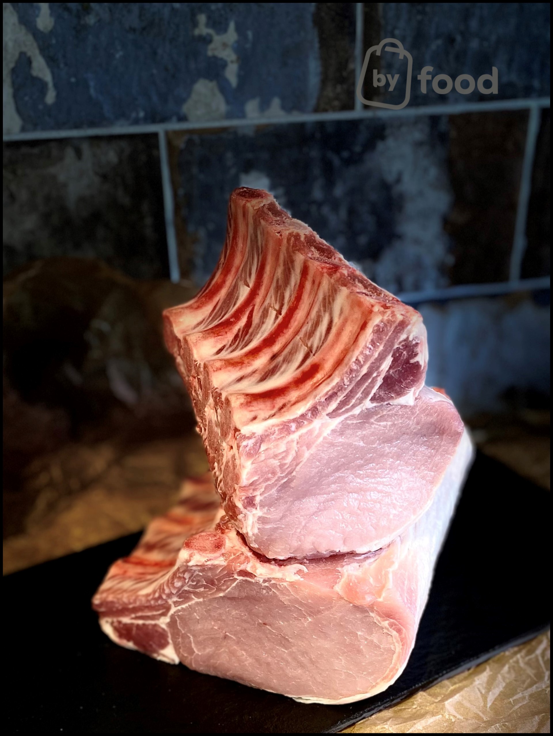 Kiaulienos nugarinė be odos su kaulu 1 kg. (+- 3%)